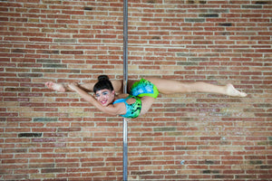 pole fitness: woman smiling while pole dancing