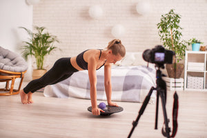 woman taking a video while using a balance board